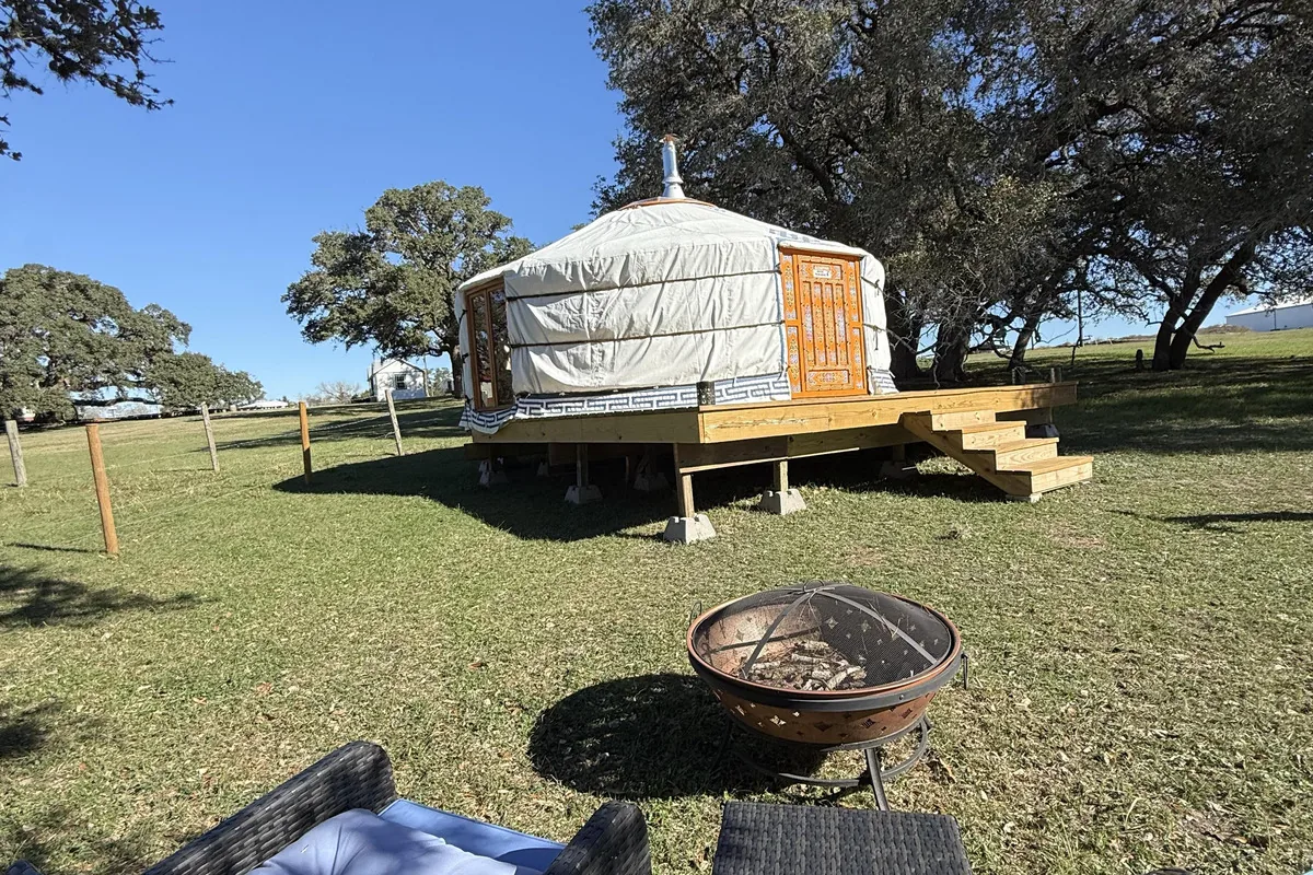 Round yurt with an orange door at Twin Oaks